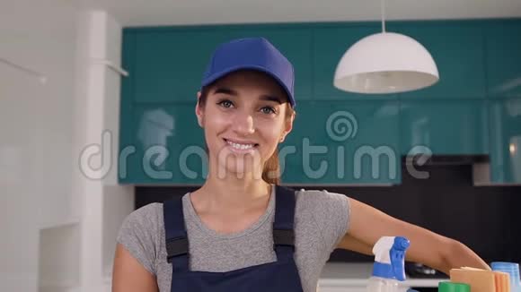 在高科技厨房里穿着带洗涤剂的蓝帽篮子的年轻女子微笑着视频的预览图