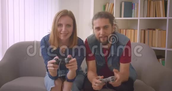 这对年轻夫妇在家玩游戏时会使用操纵杆来吸引他们的注意力视频的预览图