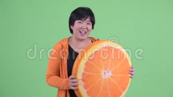 快乐年轻体重超重的亚洲女性带着橙色枕头为健身做好准备视频的预览图