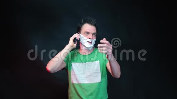 一个脸上带着剃须泡沫的男人正在用手机说话视频的预览图