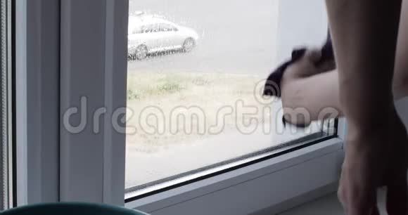 年轻女子正在家里洗窗户视频的预览图