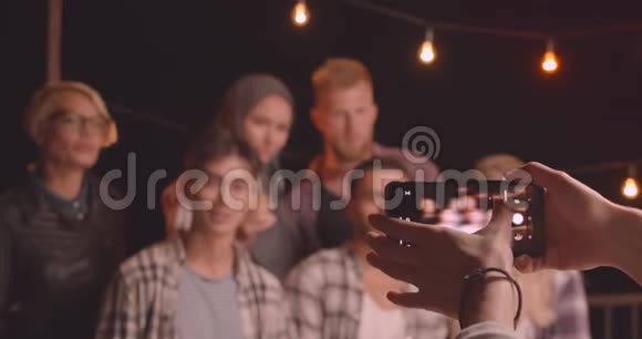 在舒适的欢乐聚会上在Instagram相机上拍摄各种不同种族的朋友的特写照片视频的预览图