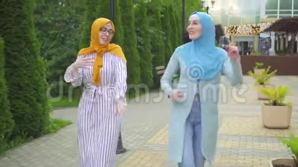 两名积极的穆斯林年轻女子在公园里跳舞视频的预览图
