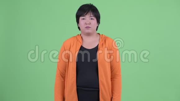 快乐的年轻超重的亚洲女人比较准备好的健身房视频的预览图