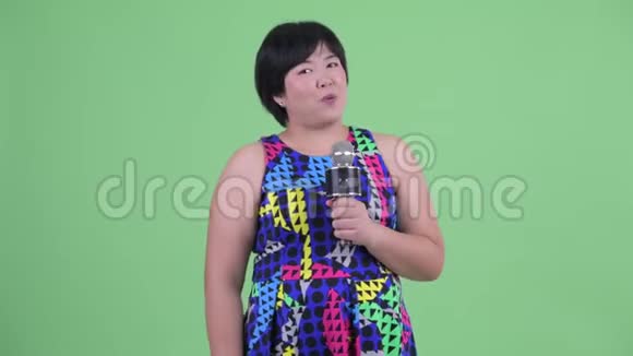 快乐年轻体重超重的亚洲女人带麦克风视频的预览图