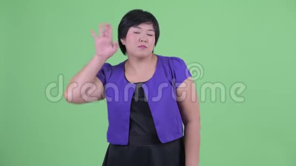 快乐的年轻肥胖的亚洲女人听着笑着视频的预览图