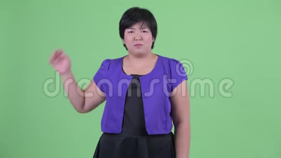 困惑的年轻超重的亚洲女人挠头视频的预览图
