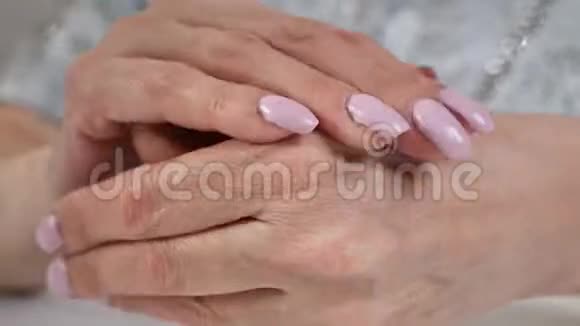 老年妇女把奶油放在手上这是一种家庭护肤的天然产品视频的预览图