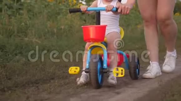 妈妈教女儿骑自行车特写镜头妈妈和她的小女儿玩小孩子学骑马视频的预览图