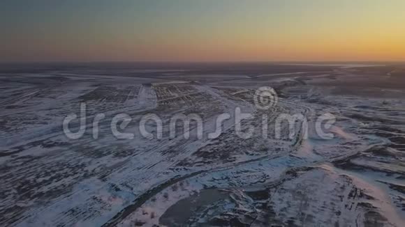 日落时分鸟瞰白雪覆盖田野视频的预览图