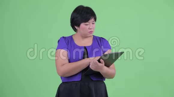 年轻美丽超重的亚洲女人拿着剪贴板指挥视频的预览图