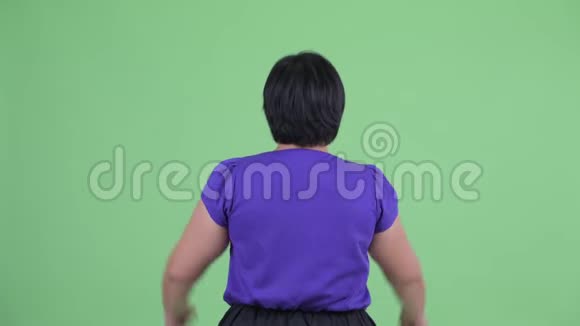 年轻体重超重的亚洲幸福女子举起拳头后景视频的预览图