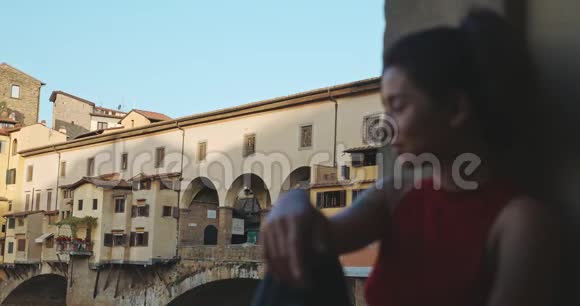 游客亚洲女孩在佛罗伦萨与庞特韦奇奥桥和阿诺河的背景年轻女子肖像视频的预览图