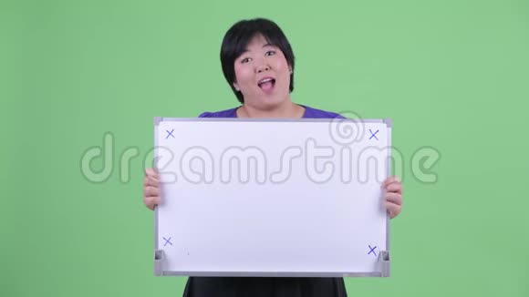 快乐年轻体重超重的亚洲女人拿着白板说话视频的预览图