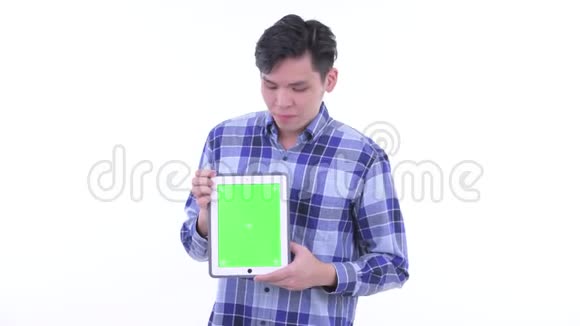 穿着时髦的亚洲年轻人展示数码平板电脑视频的预览图