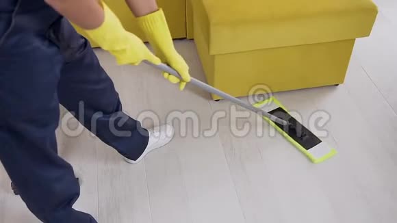 未知的清洁工人戴着橡胶手套和蓝色制服在地板上扭动视频的预览图