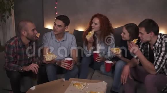 年轻人快乐的男人和女人正在吃奶酪披萨在公寓的室内聚会上聊天放松视频的预览图