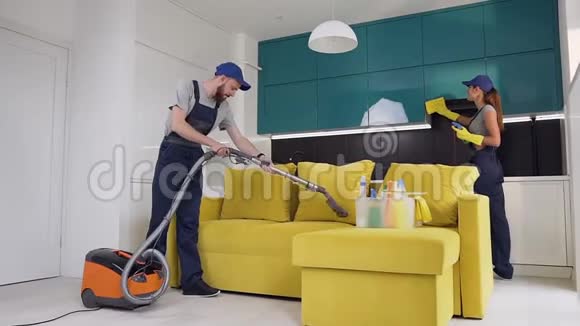从清洁服务的工人那里男人在沙发上吸尘女人在擦拭家具他们的照片很有吸引力视频的预览图