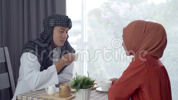 年轻的穆斯林使用智能手表非接触支付咖啡厅视频的预览图