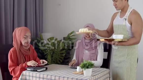 年轻的女服务员给两个穆斯林女人端咖啡视频的预览图