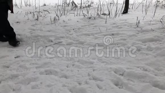 一位手持拐杖的老人在白雪覆盖的小路上艰难行走视频的预览图