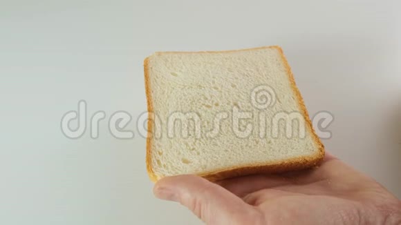 人们用刀子慢慢地在面包上撒白色黄油视频的预览图