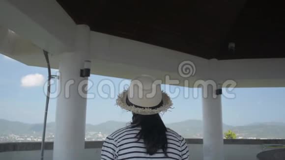 亚洲可爱的女孩穿着休闲装戴着草帽走进观景塔欣赏美丽的风景视频的预览图