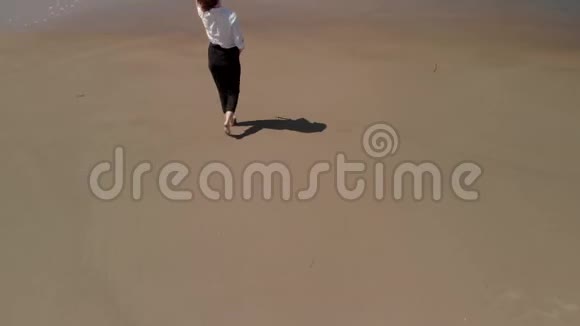 一位年轻的年轻女士在海滩上眺望林肯市附近俄勒冈海岸开阔的海洋视频的预览图