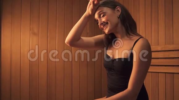 女士坐在桑拿浴室里向前看微笑视频的预览图