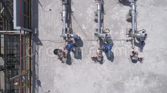 2名工程师在晴朗天气工作的工厂上空的空中飞行视频的预览图