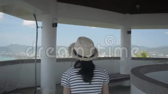 亚洲可爱的女孩穿着休闲装戴着草帽在观景塔散步欣赏令人叹为观止的风景视频的预览图