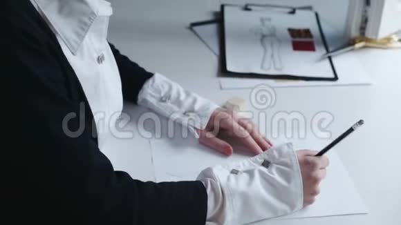 成功的时装设计师的画像画了一件在车间里的衣服的草图视频的预览图