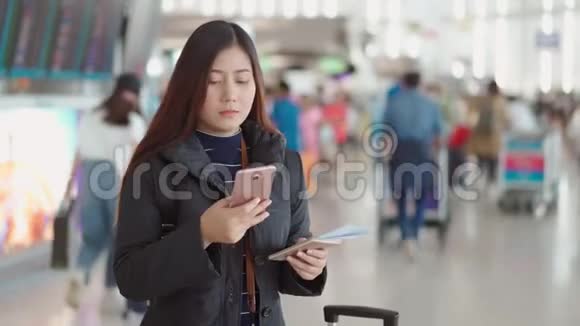 年轻旅客女性在机场用智能手机办理登机手续视频的预览图