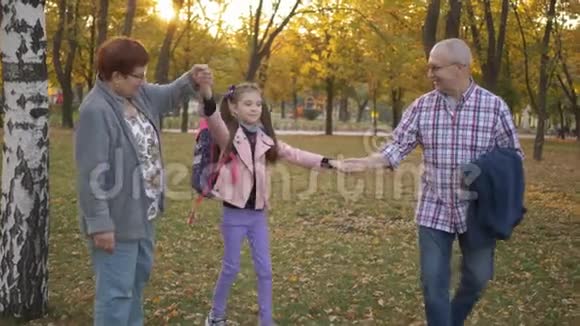 祖父母和她的孙女在秋天公园玩和玩视频的预览图