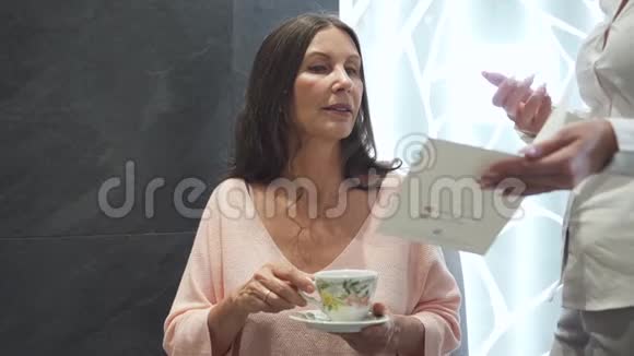 微笑友好的女人坐着喝着美味的茶视频的预览图