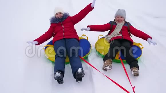 冬天的孩子们在雪地里乘坐充气雪管扮演超级英雄孩子们在冬季度假胜地快乐视频的预览图