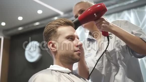 当理发师擦干湿发时男人在等待视频的预览图