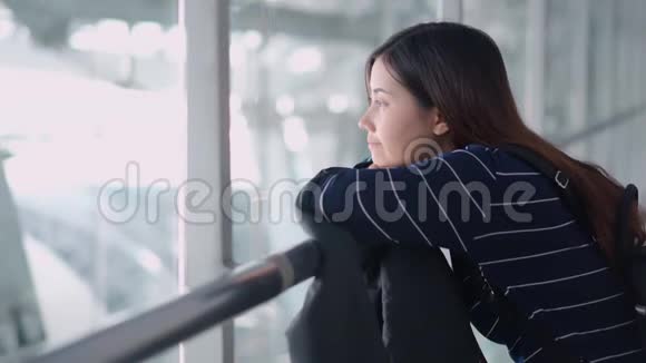 年轻的女旅客在机场等候时眺望视频的预览图