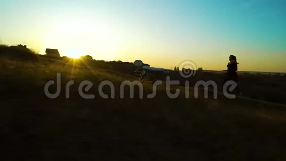 女孩和美国斯塔福德郡的猎犬在夕阳下奔跑视频的预览图