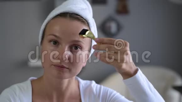 美女正在使用真皮滚筒女人用美索罗勒在脸上做针头手术视频的预览图