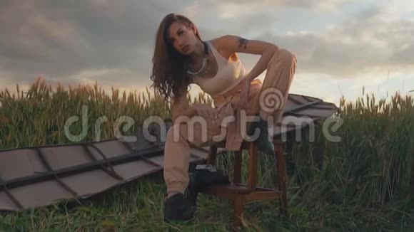 有长发的女士坐在凳子上靠在棕色滑翔翼上视频的预览图