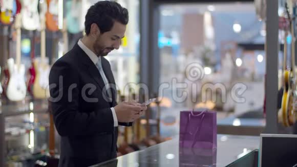 年轻的帅哥用智能手表在柜台上非接触支付视频的预览图