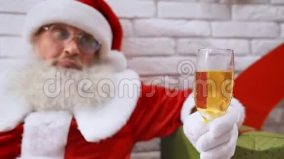 成熟的圣诞老人在工作室里喝着香槟视频的预览图