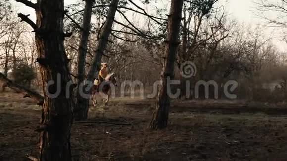 骑马时在树林中缓慢行进的女骑手的侧视视频的预览图