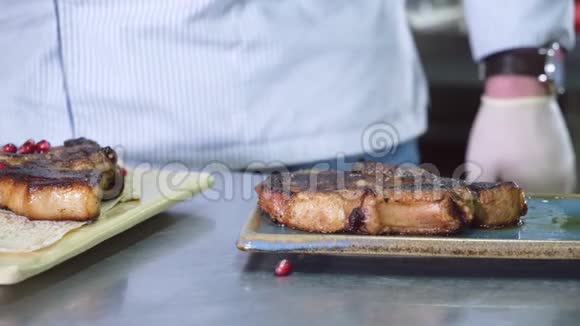 厨师把酱汁放在盘子里准备好的猪肉牛排放在面包皮塔洋葱和石榴上视频的预览图