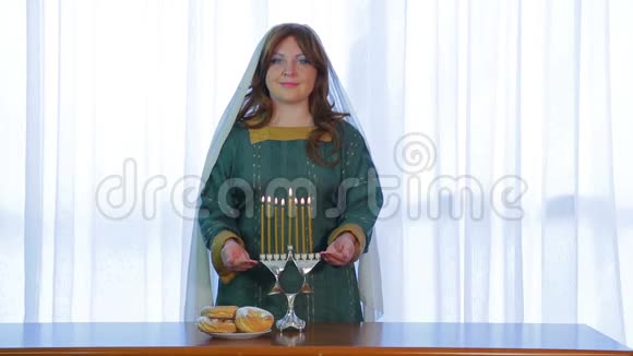 一位犹太妇女站在光明节上点燃蜡烛微笑着视频的预览图