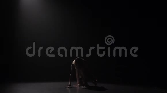 老练的女孩在黑背景下在演播室跳舞慢动作视频的预览图