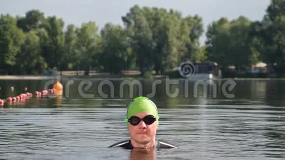 阳光明媚的一天专业游泳运动员在湖中游泳只有运动员的头在水面上可见关门视频的预览图