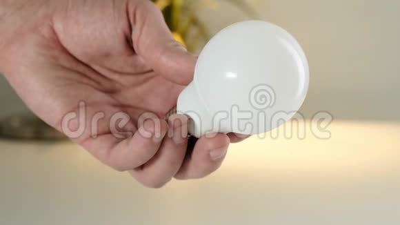 雄性手拿着一个白色玻璃灯泡视频的预览图