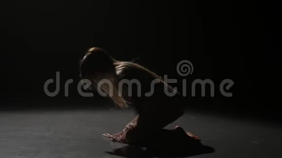 黑暗的工作室长发女人在黄昏中跳舞慢动作视频的预览图